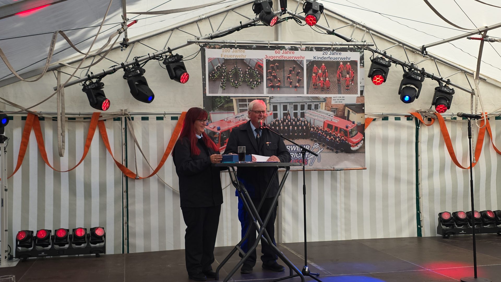Festrede auf der Bühne vor dem Jubiläumsbanner